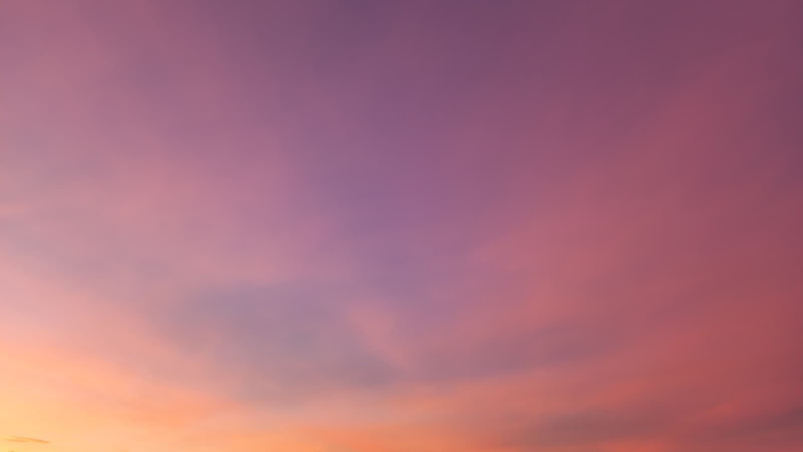 Warm coral-plum dusk sky over silhouetted ridge